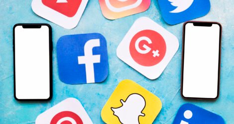 social-media-icons-with-two-blank-cellphone-blue-painted-wall