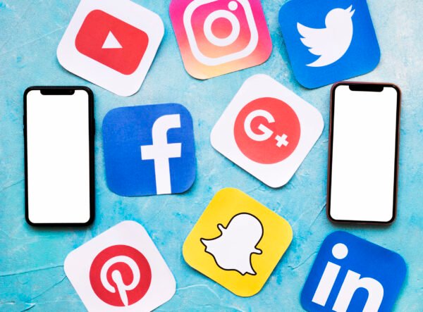 social-media-icons-with-two-blank-cellphone-blue-painted-wall
